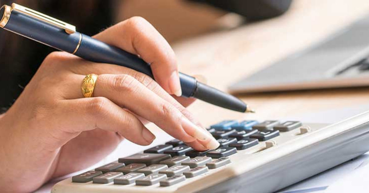 hand holding a pen and using a calculator